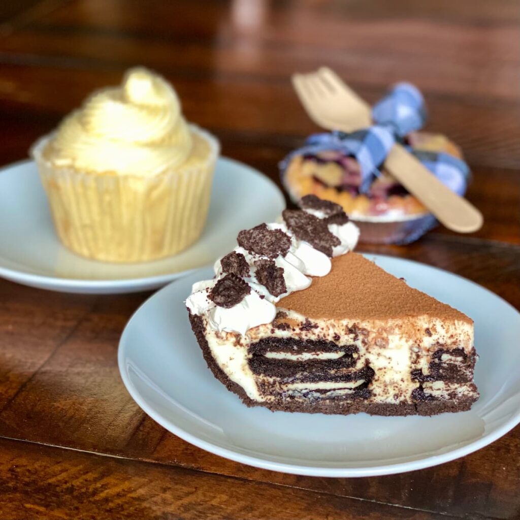 Oreo tiramisu pie on a plate with a pie cupcaken and a mini pie behind